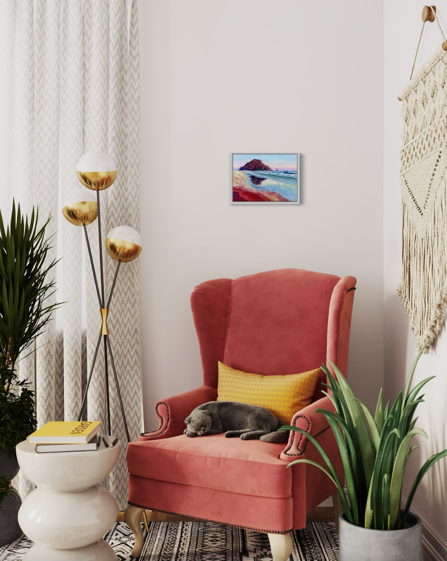 Pink armchair with a gray cat, yellow pillow, and decorative items in a room.