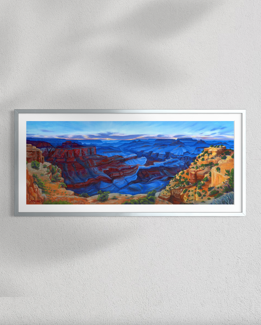 Framed painting of a canyon landscape on a white wall
