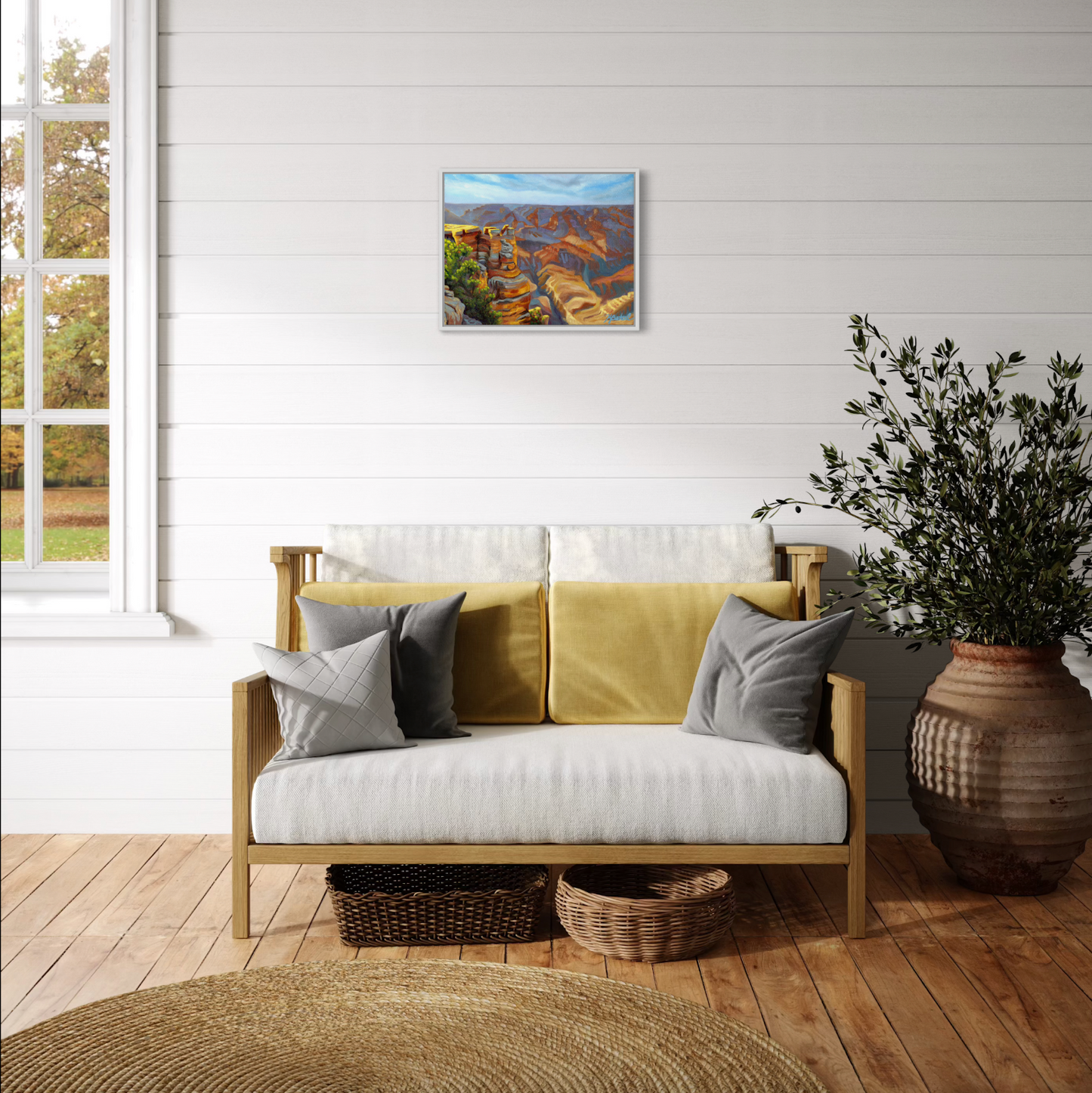 Living room with a beige sofa, decorative pillows, and a painting on the wall.