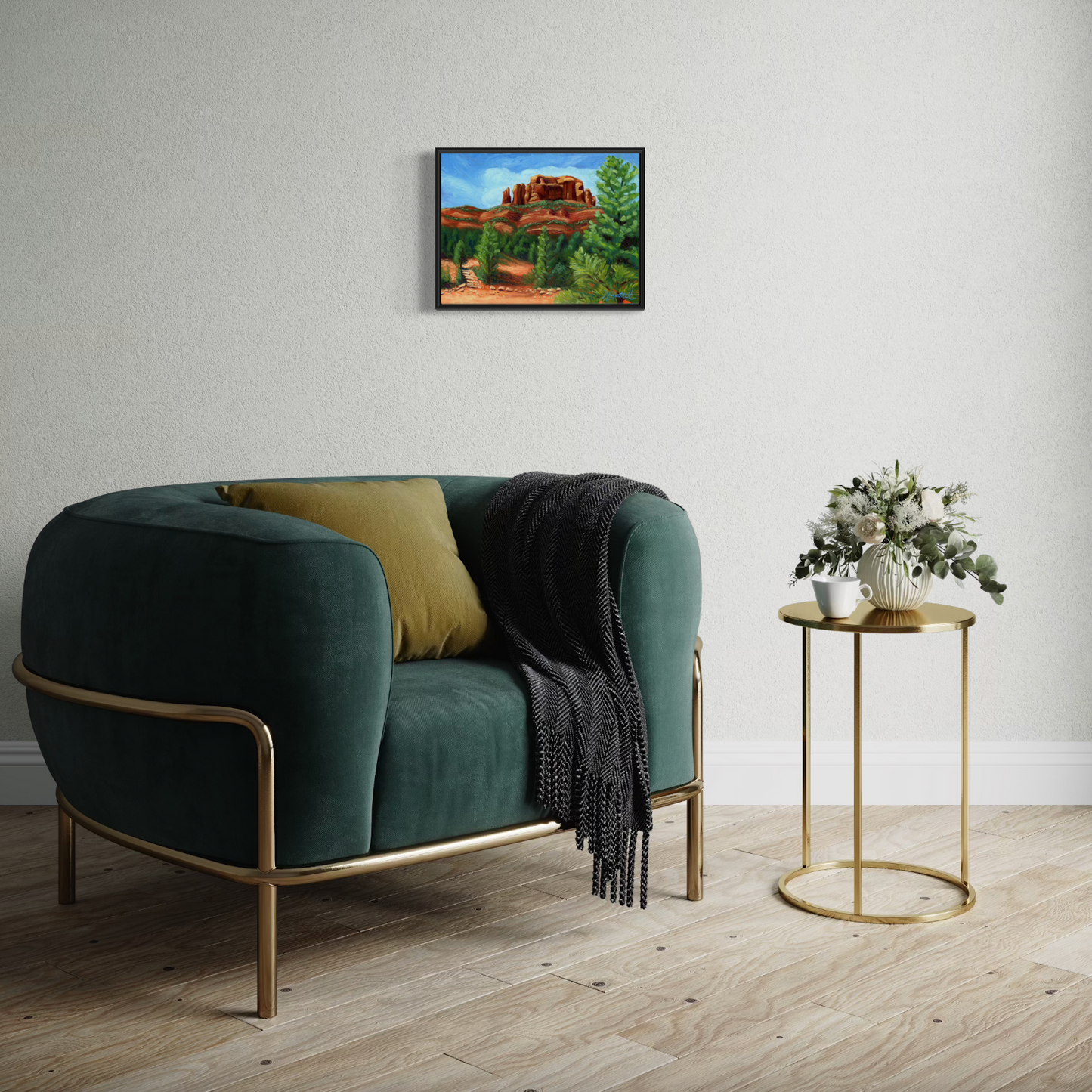 Green sofa with gold frame in a room with a painting on the wall and a side table with flowers.