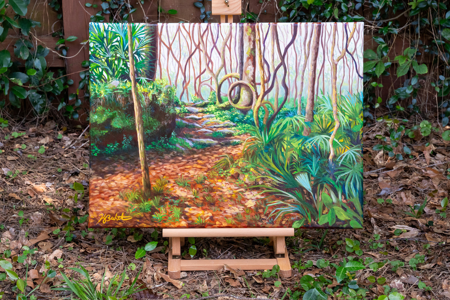 Painting of a forest path on an easel outdoors