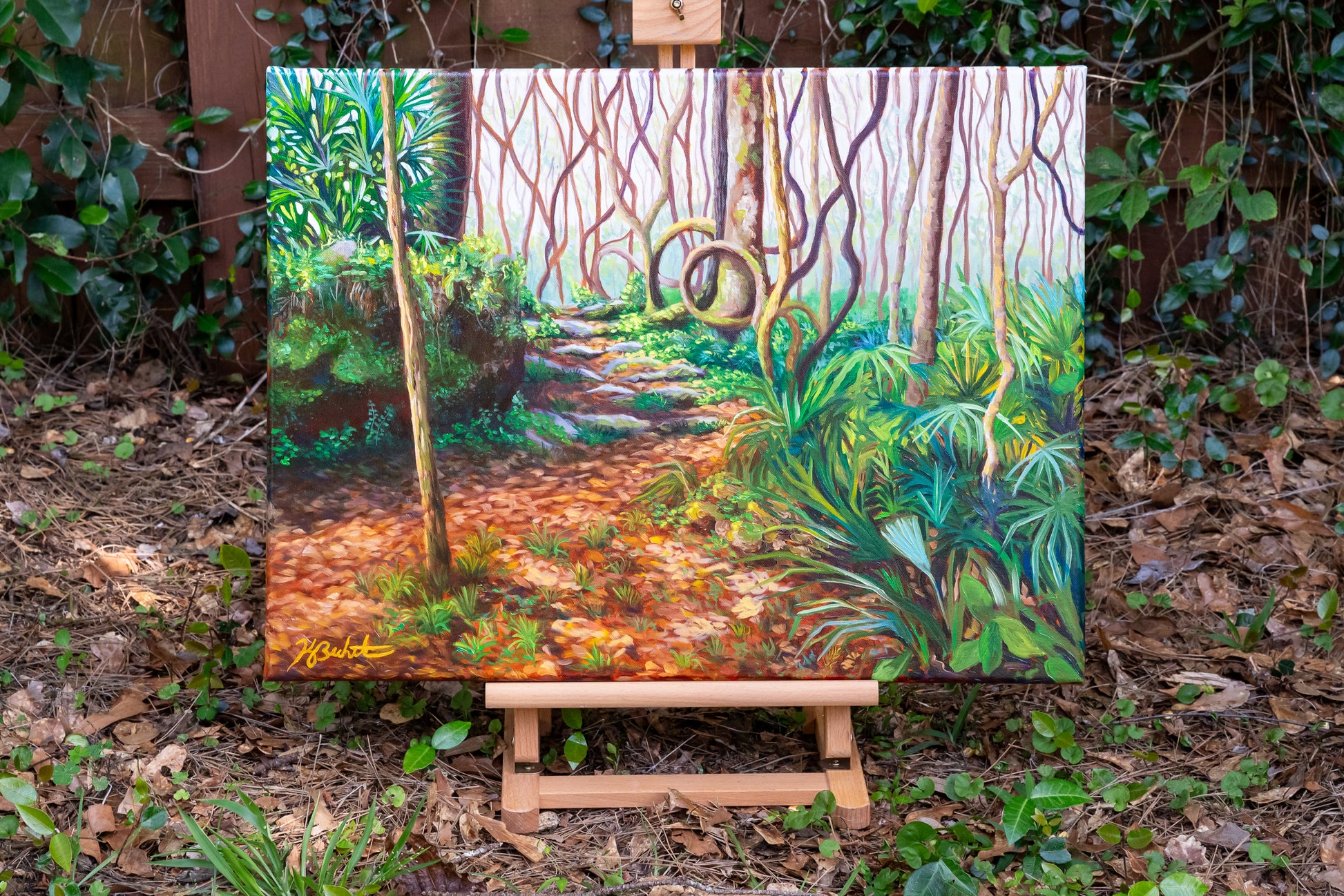 Painting of a forest path on an easel outdoors