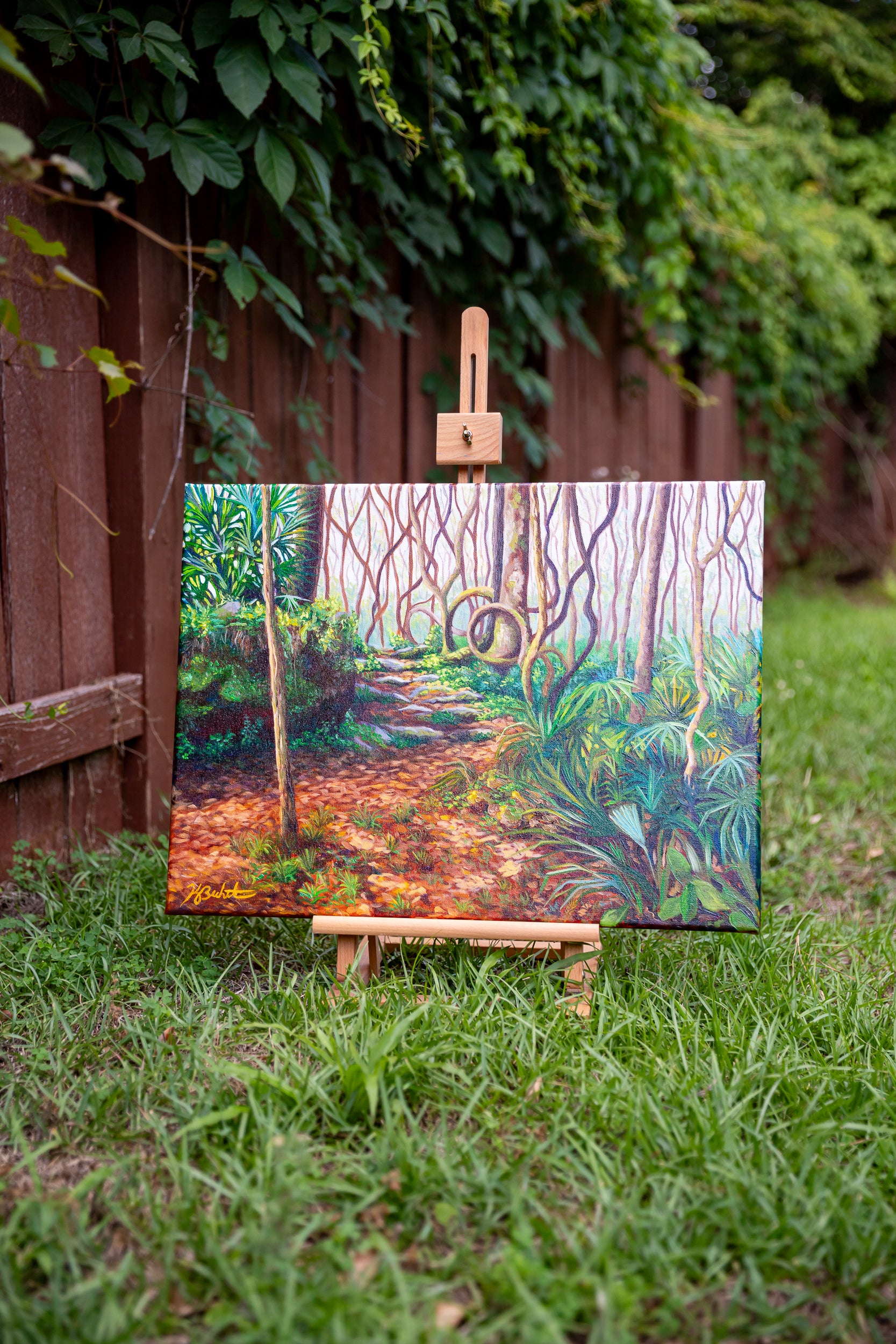 Painting of a forest path on an easel outdoors
