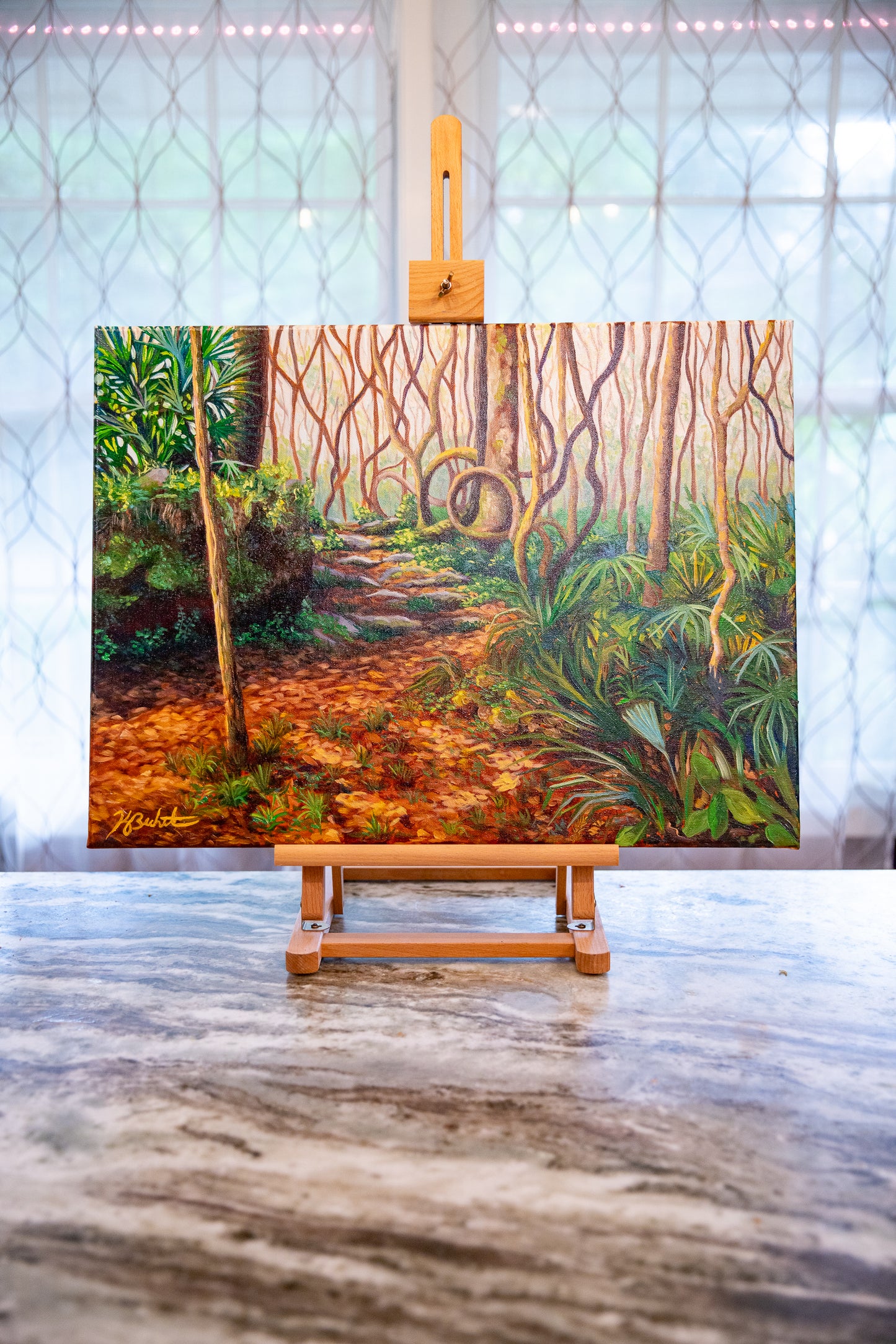 Painting of a forest path on an easel with a marble floor and windowed wall background