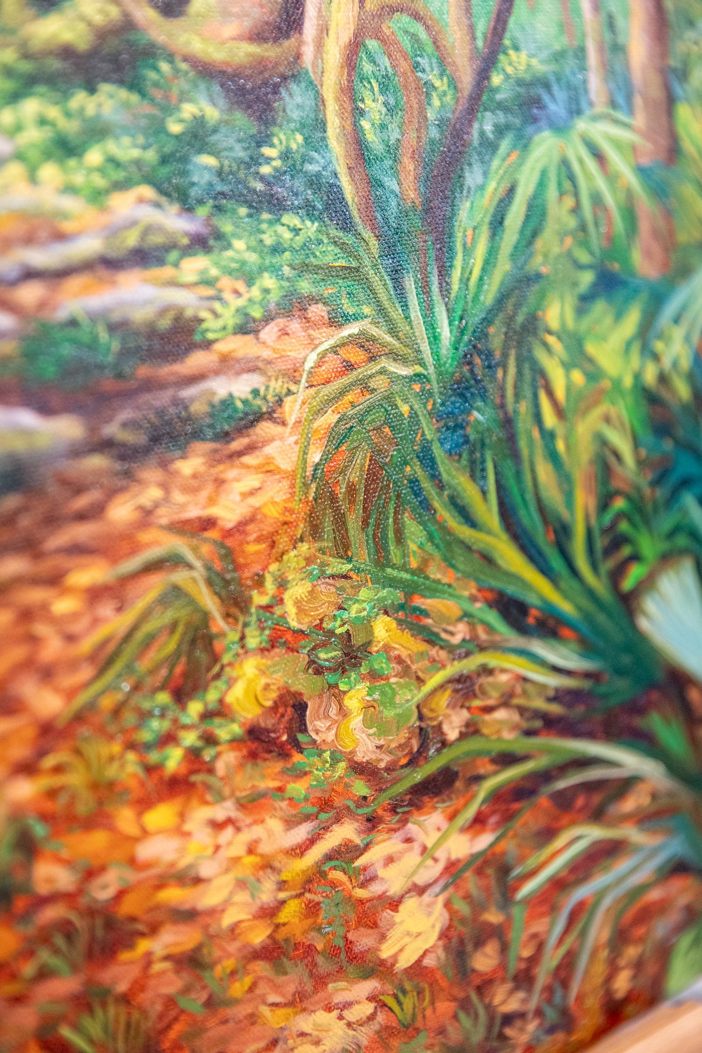 Close-up of a painting with vibrant green plants and earthy tones