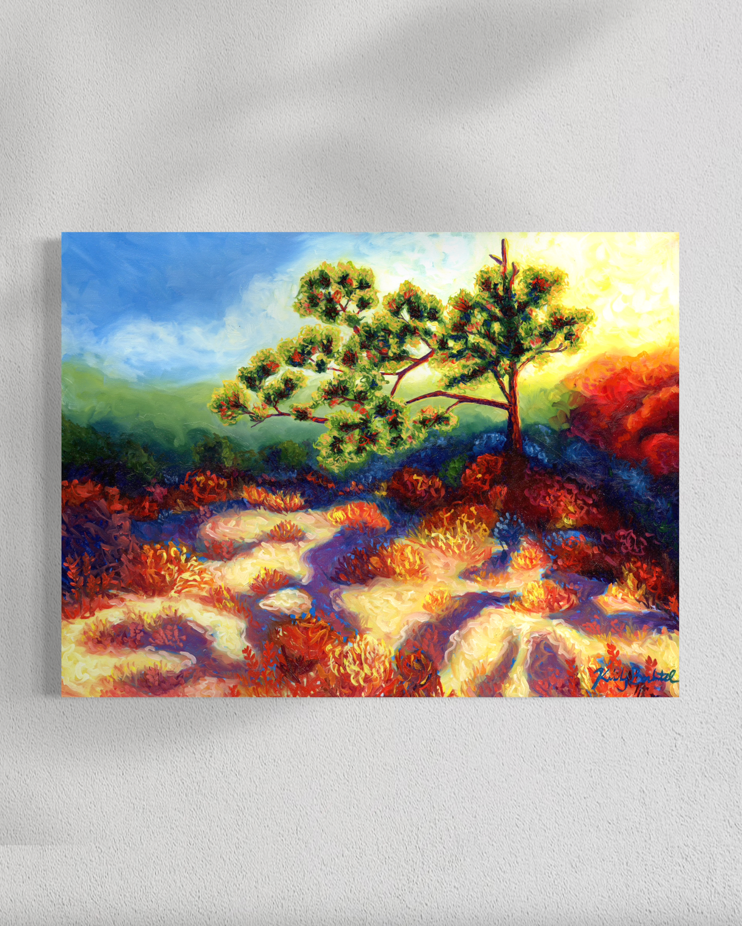 Painting of a tree with a colorful landscape on a white wall