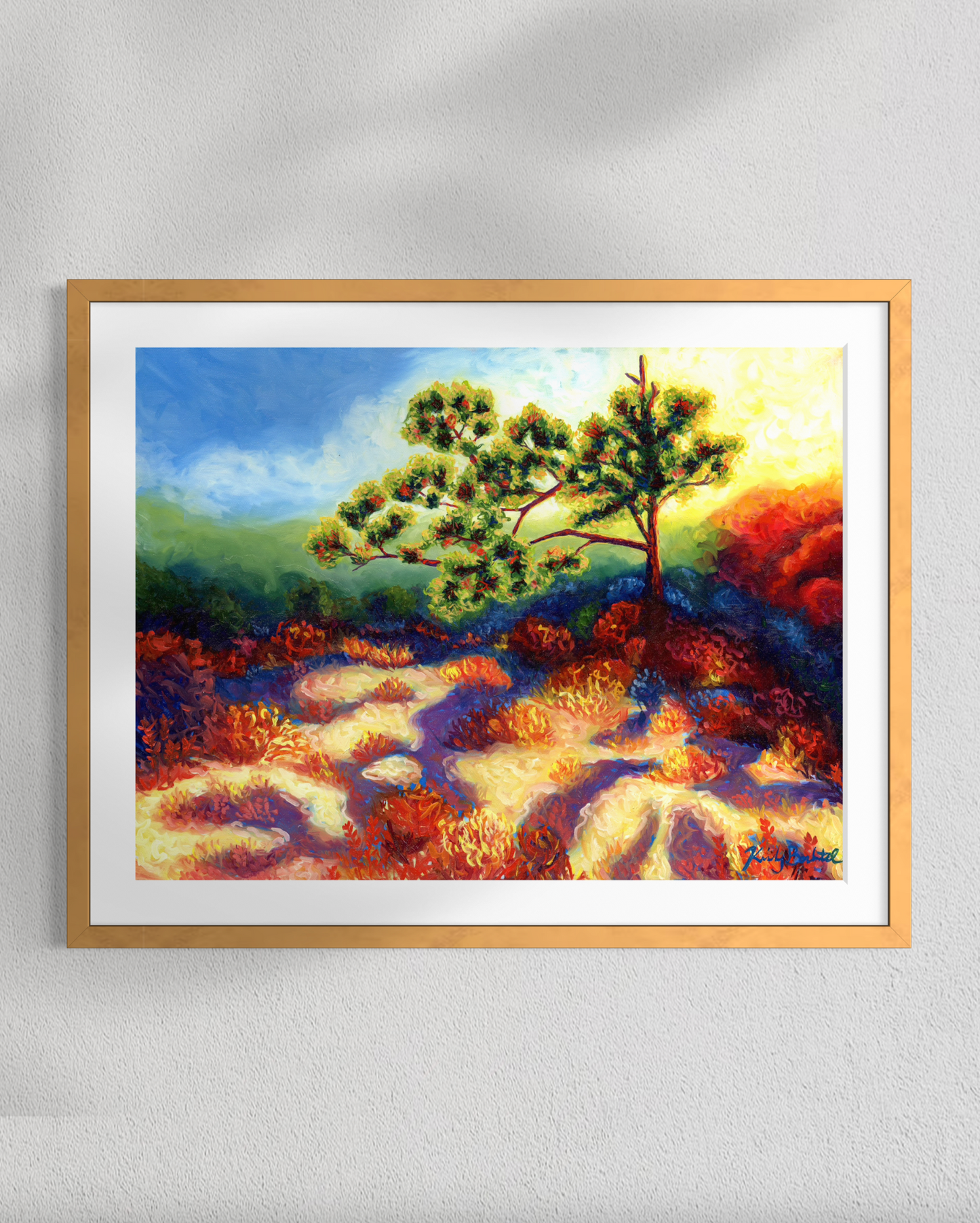 Framed painting of a tree with colorful landscape on a white wall
