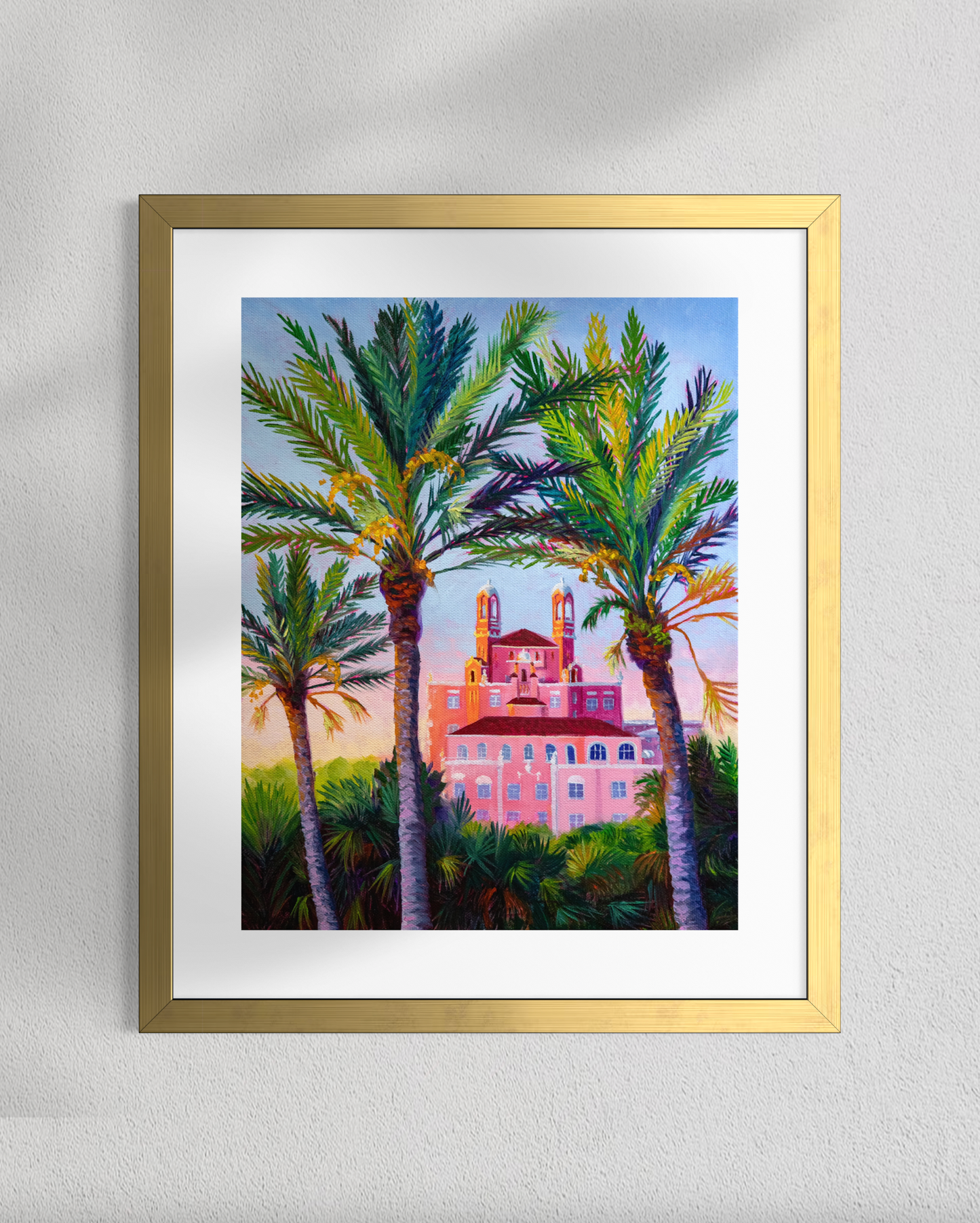 Gold-Framed painting of palm trees and a building on a gray wall