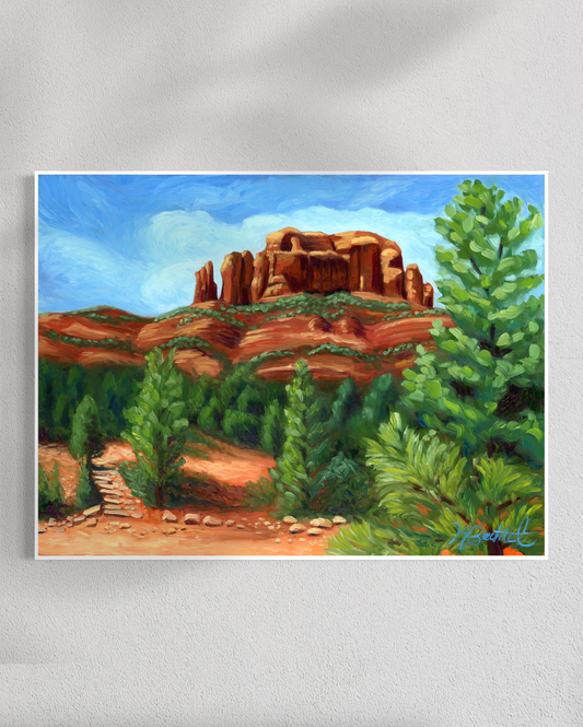 Painting of a desert landscape with red rock formations and green trees on a white wall.
