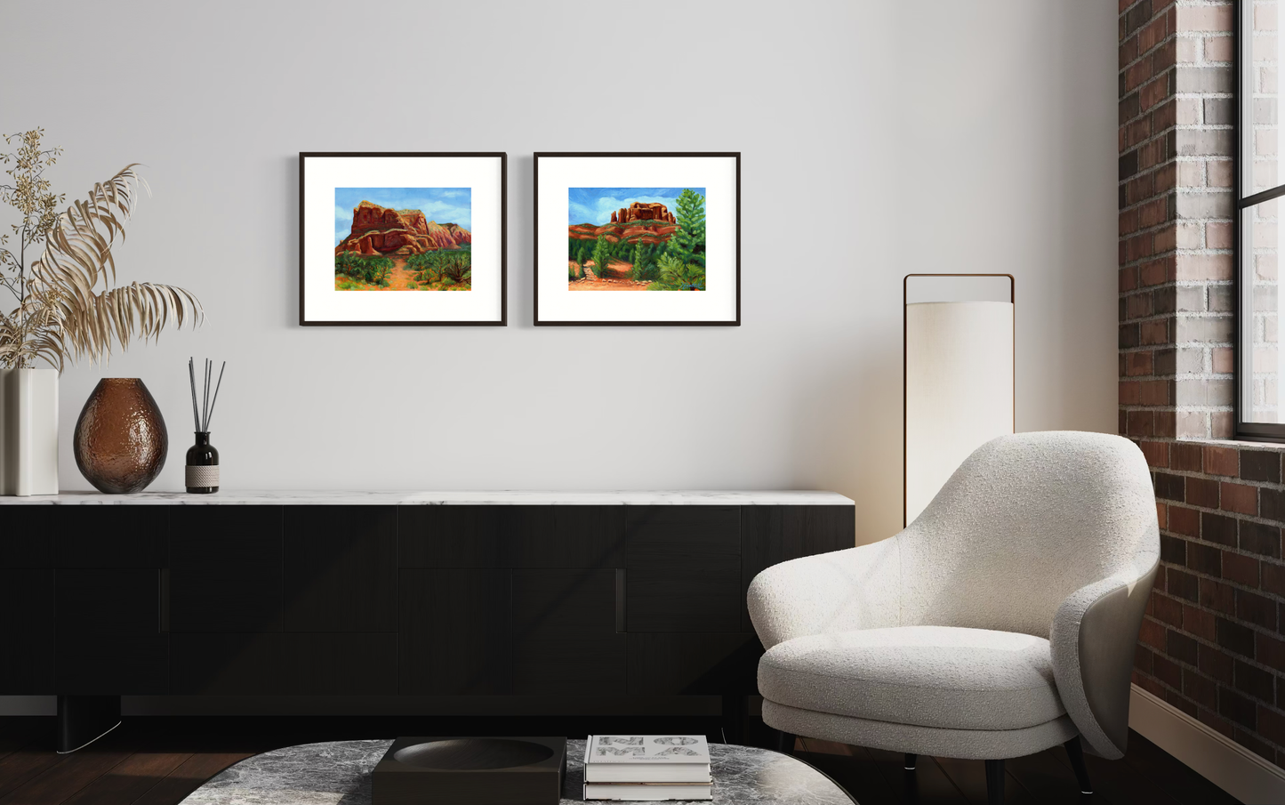 Modern living room with a white armchair, side table, and framed landscape pictures on the wall.