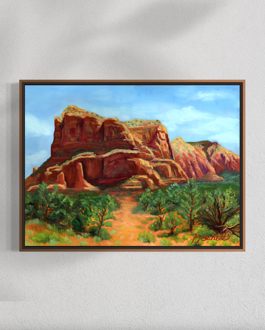 Framed painting of a desert landscape with red rock formations and green trees.