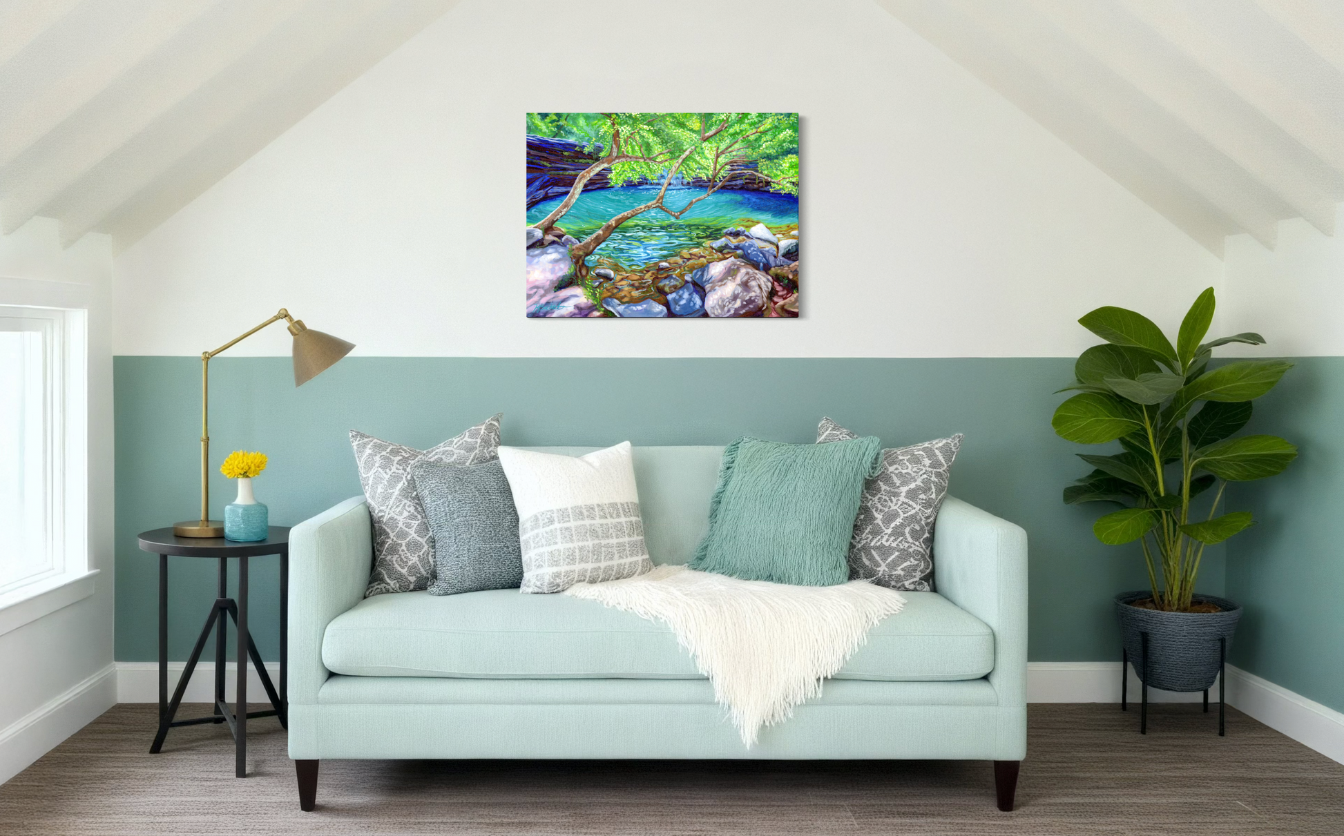 Living room with a light blue sofa, decorative pillows, and a painting of a natural scene on the wall.