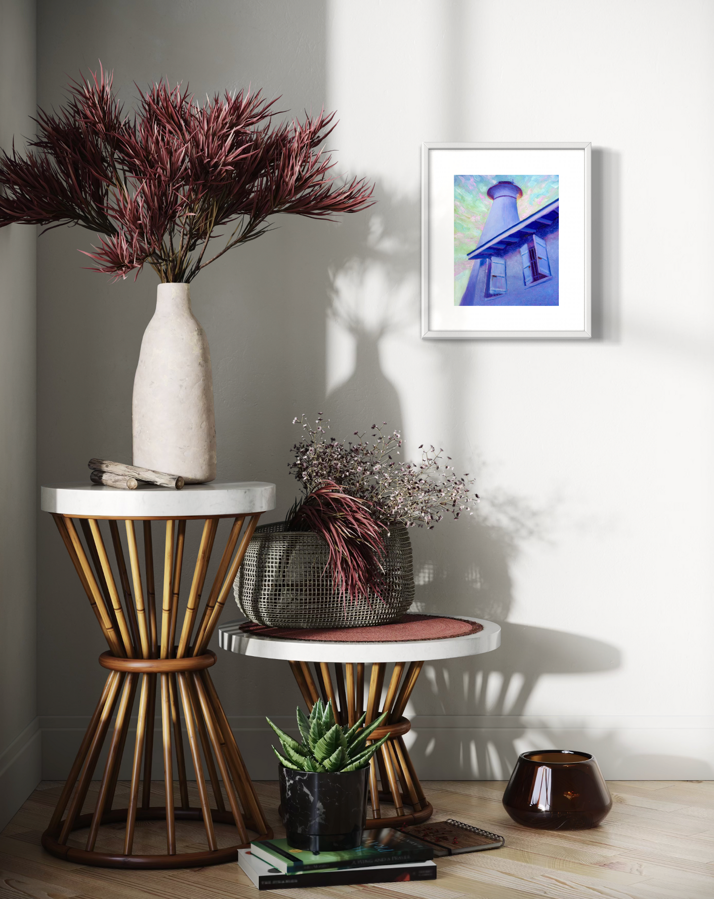 Decorative setup with a vase, plants, and framed artwork on a wall.