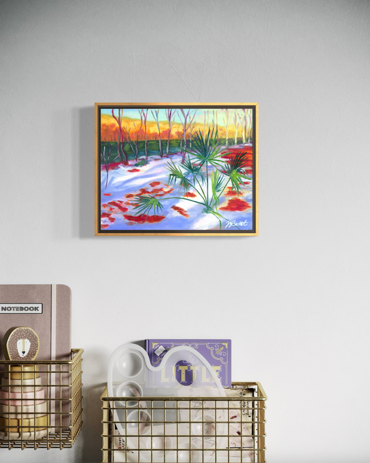 Framed artwork of a snowy landscape with trees and flowers on a wall above a gold wire basket.