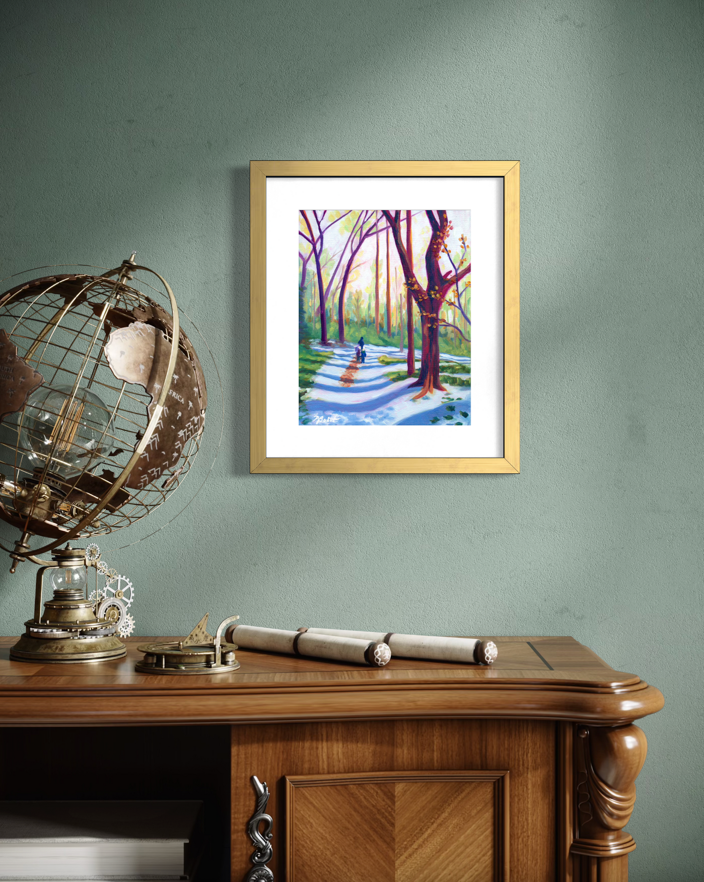 Framed artwork of a forest scene on a wall above a wooden desk with decorative items.