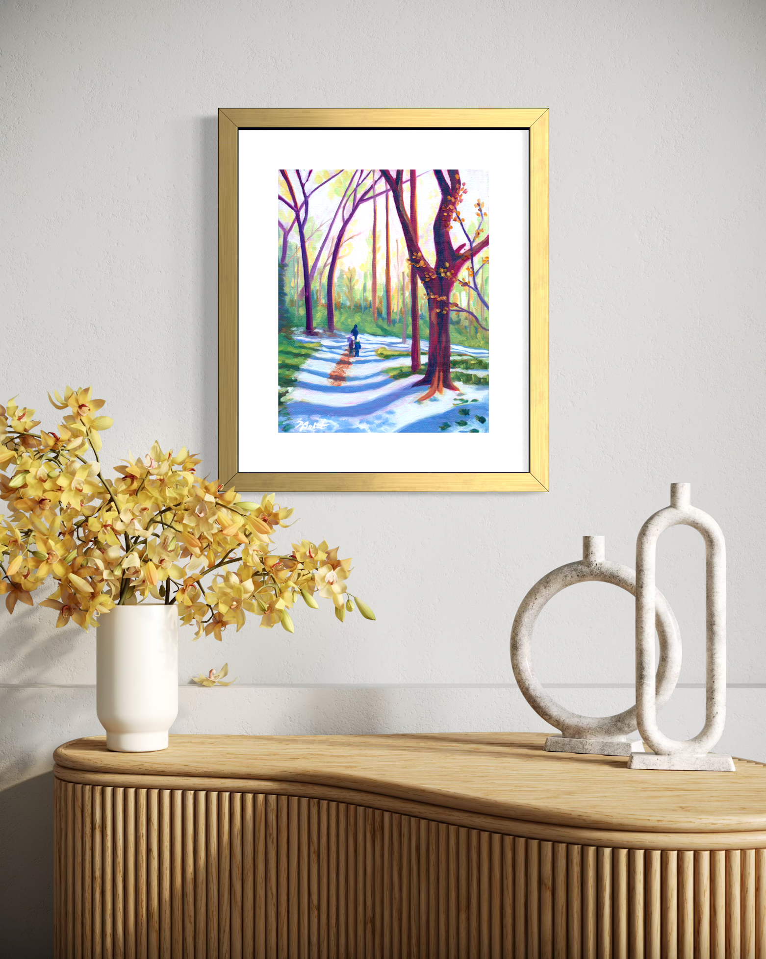 Framed artwork of a park scene on a wall above a wooden console table with decorative items.