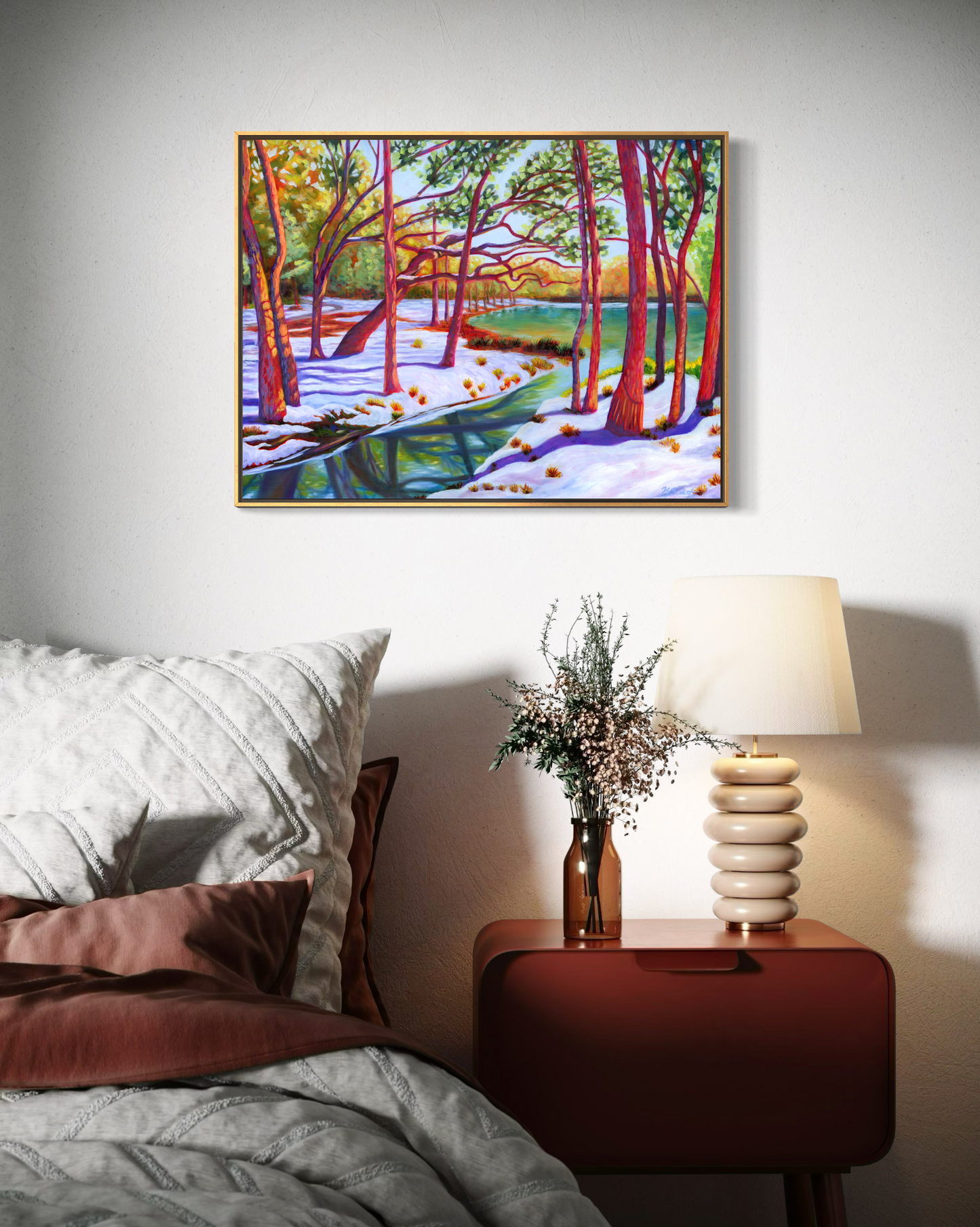 Bedroom with a painting of a snowy forest, lamp, and vase on a nightstand.