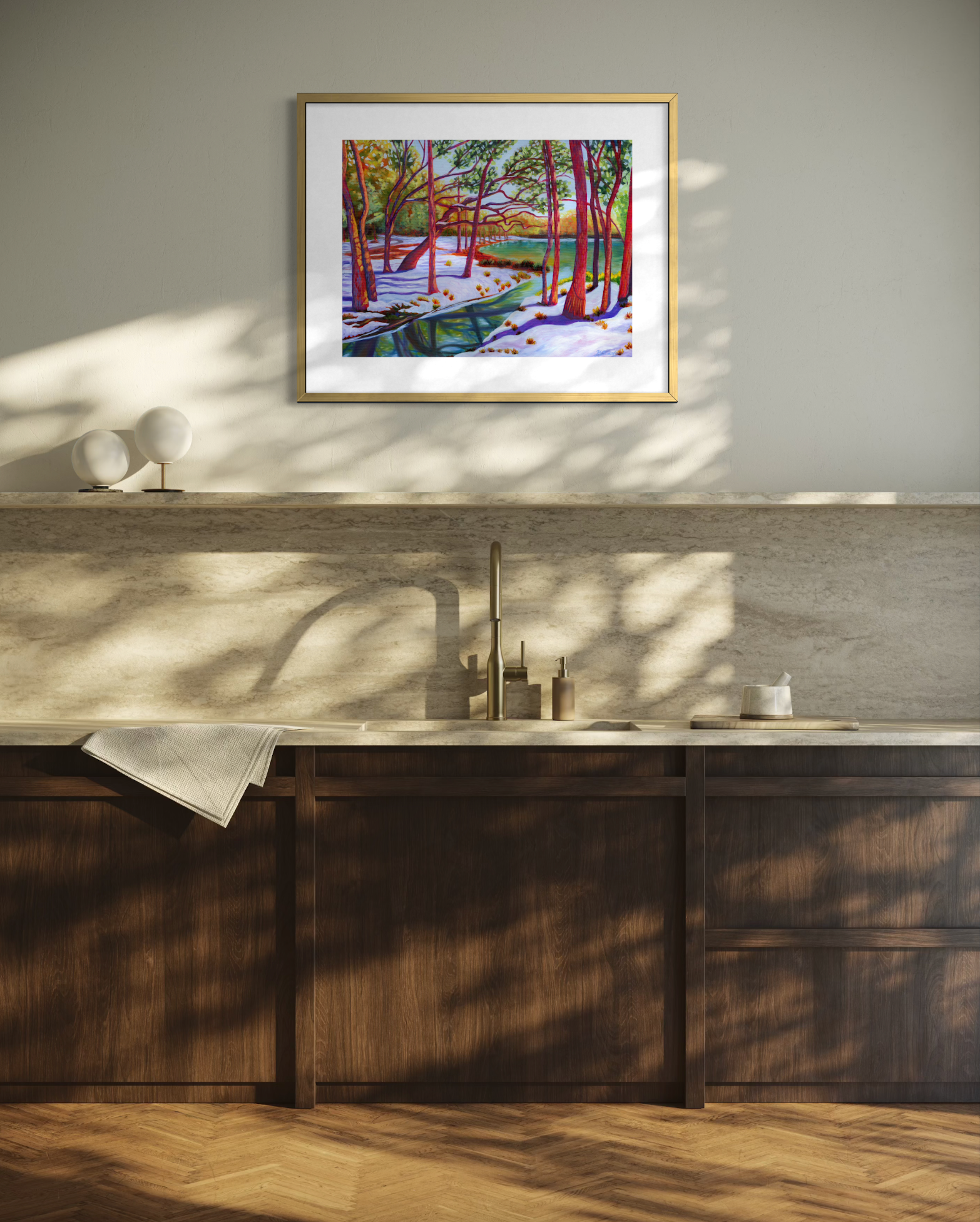 Framed artwork on a wall above a wooden counter with a sink.