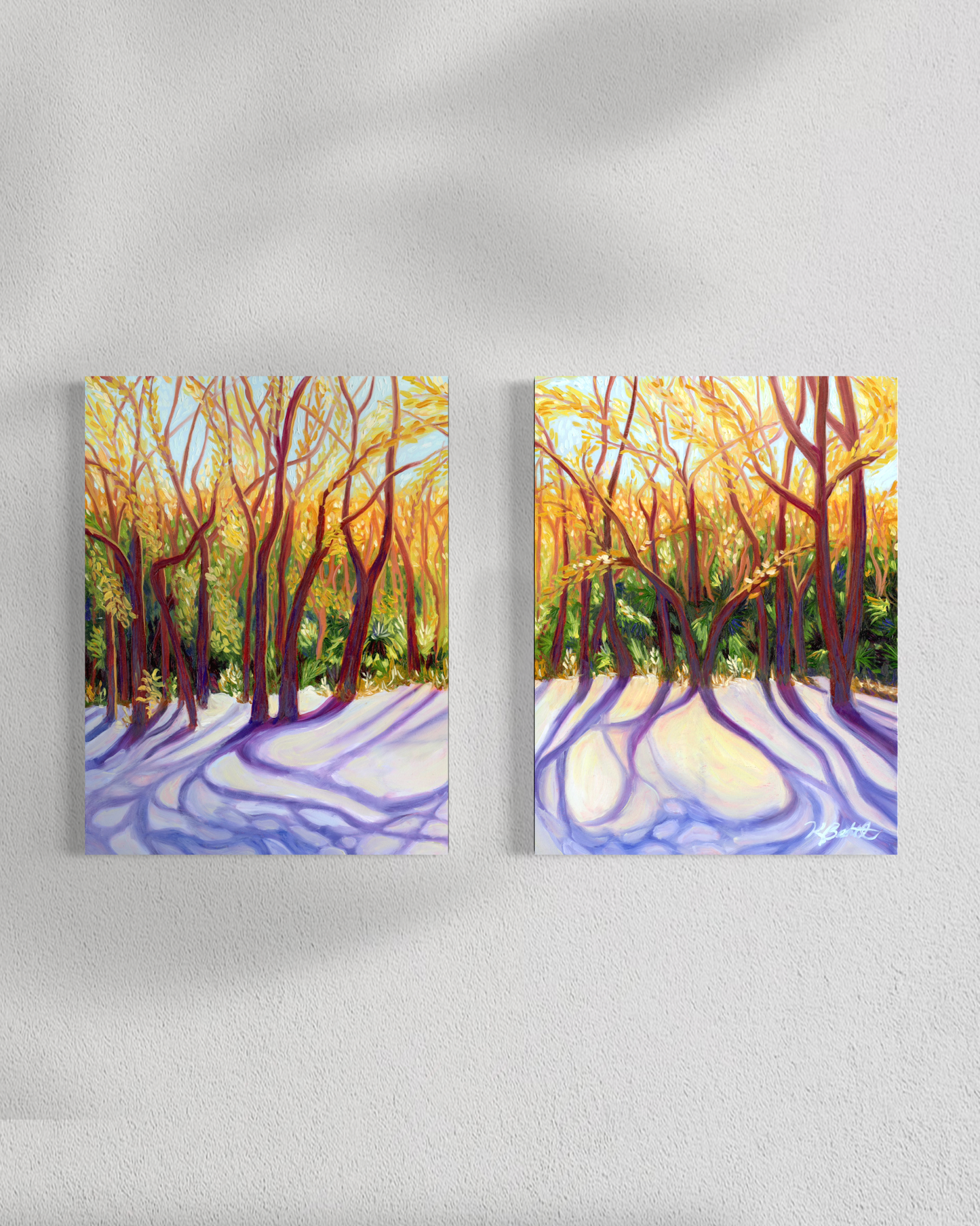 Two canvas prints of a forest scene with sunlight filtering through the trees on a white wall.
