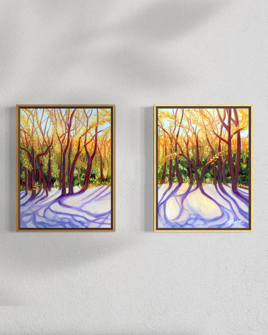 Two framed paintings of a forest scene with sunlight on a white wall.