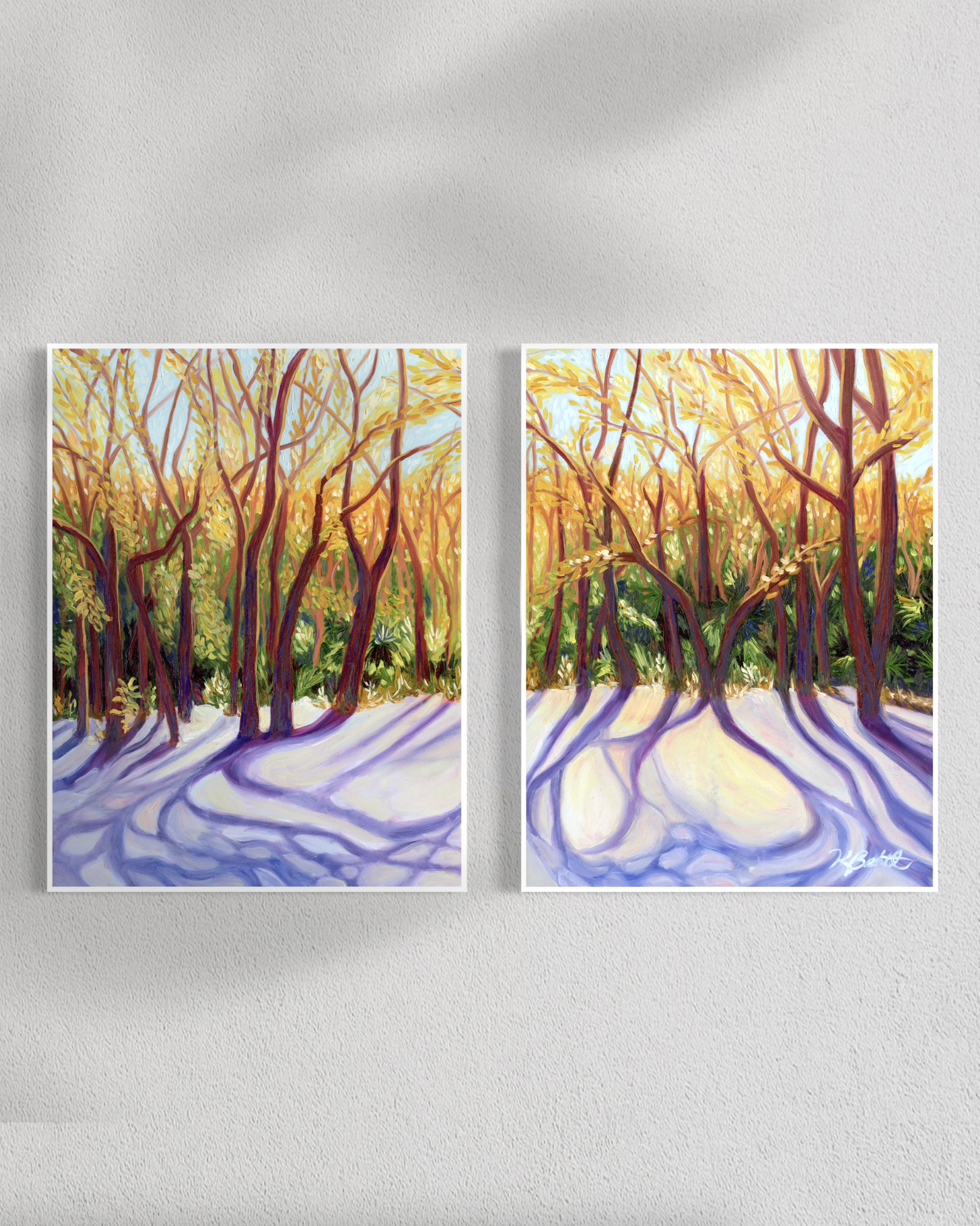 Two paintings of a forest scene with sunlight filtering through the trees on a white wall.