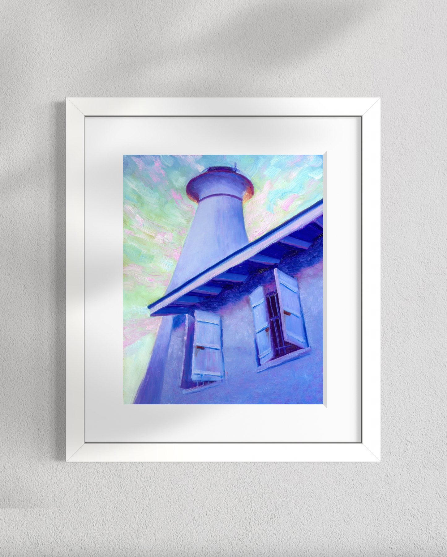 Framed artwork of a painting of a lighthouse with a colorful sunset sky.