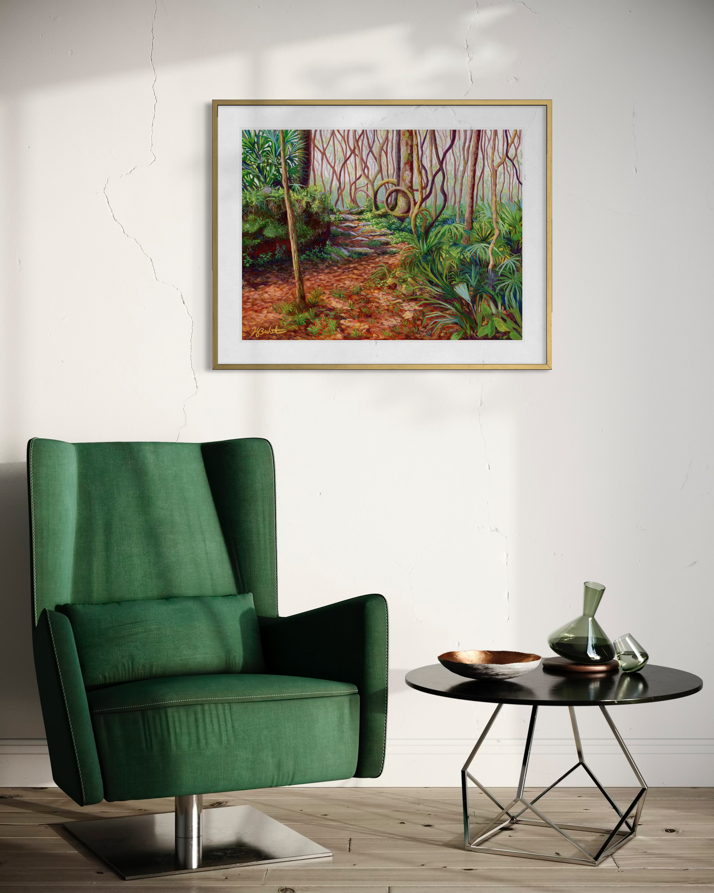 Green armchair in a room with a painting of a forest on the wall and a small table with decorative items.